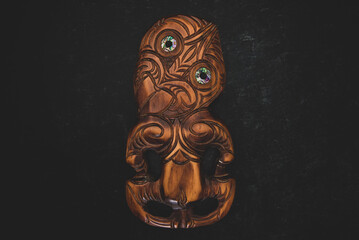 Wooden Maori Hei Tiki hand carved with paua shell eyes. New Zealand taonga. - obrazy, fototapety, plakaty