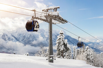 Neue, moderne, geräumige Großkabinen-Skilift-Gondel gegen schneebedeckte Waldbäume und Berggipfel, die mit einer Schneelandschaft im luxuriösen Winter-Alpenresort bedeckt sind. Winterfreizeitsport, Erholung und Reisen