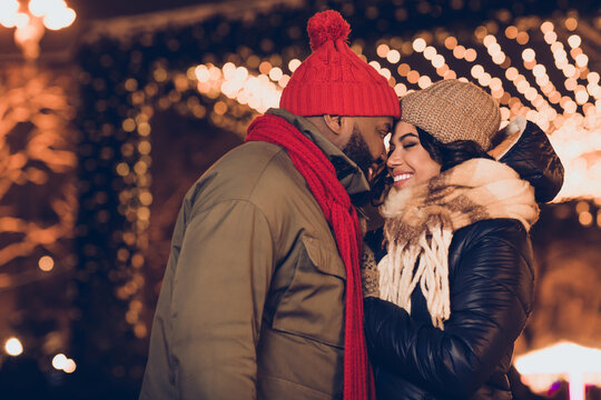 Profile side view portrait of attractive affectionate cheerful couple wife husband visiting festal fair eve cuddling city urban outdoors - Powered by Adobe
