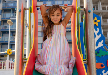 Little cute child girl in playground on the beach with smile on summer vacation. Happy children kid enjoy and fun outdoor activity lifestyle