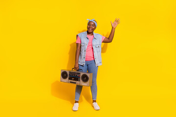 Full size photo of funky person hold boombox raise arm palm waving isolated on yellow color background