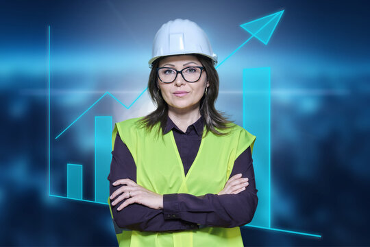 Factory engineer woman in safety helmet vest posing on industrial background with graphs
