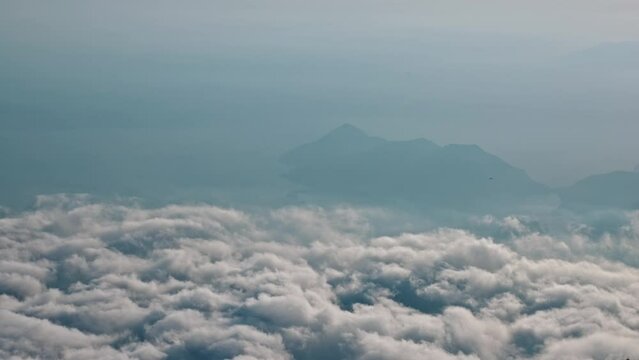 Time lapse View from mountain above clouds against background Island Sea. Moving clouds Bird flight Sunset light. 