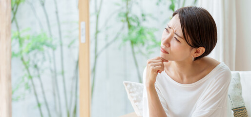 リビングで考え事をする主婦