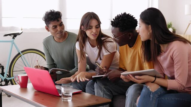 Four multiethnic young students learning together at home. Millennial people of diverse ethnic studying and preparing for university exam. High quality 4k footage