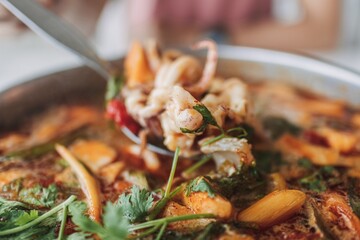 Tom Yam Ta Lay or Tom Yam Seafood. Popular hot and spicy Thai food on the beach.