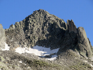 Alpine rocky peak Pizzo della Valletta (2726 m) above the reservoir lake Lago di Lucendro in the Swiss mountain area of St. Gotthard Pass (Gotthardpass), Airolo - Canton of Ticino (Tessin) Switzerland