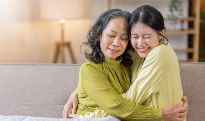 Candid attractive cute mum sit at cozy sofa couch living room, Asian family moment grown child kid...