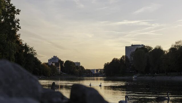 River Danube between trees and buildings in Ulm at colorful sunset  time lapse