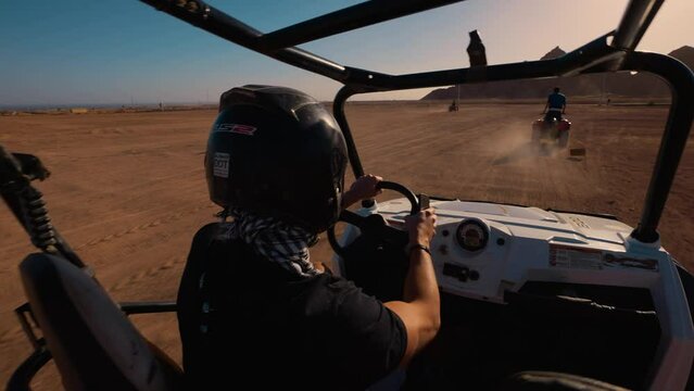 Libyan desert in Egypt. Sharm El Sheikh. Buggy desert safari. A driver in a motorcycle helmet drives a buggy.