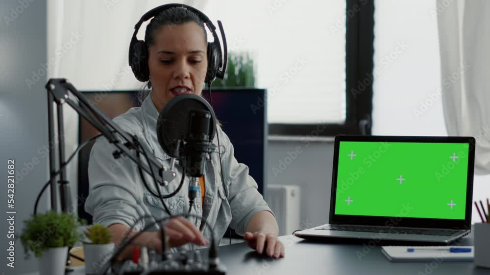 Poster influencer in studio presenting product on laptop with green screen background. creative content cre