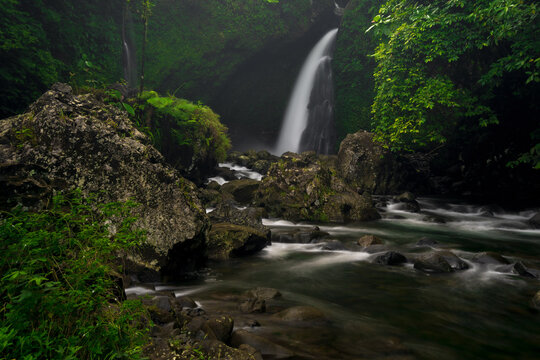 Indonesian landscape photo with waterfall in the morning and beautiful green tropical forest