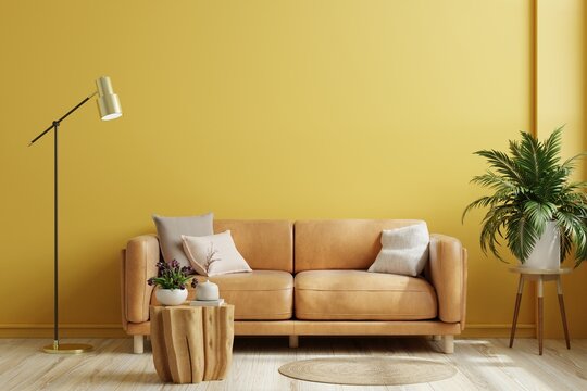 Yellow wall interior living room have orange leather sofa and decoration minimal.