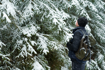 Winter season. Traveler in winter snowy forest.man with a backpack in snowy weather. Snowfall in the winter forest.