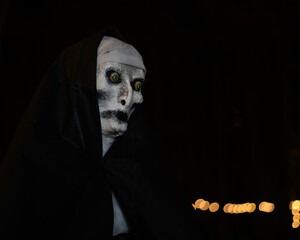 Halloween manikin featuring nun in black hood and cloak at night