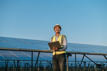 Fototapeta premium Young Asian technician man checking operation photovoltaic solar panel