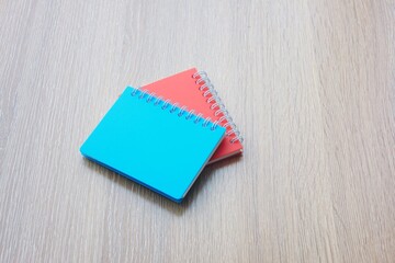 Colorful notepad and pencil on a wooden background