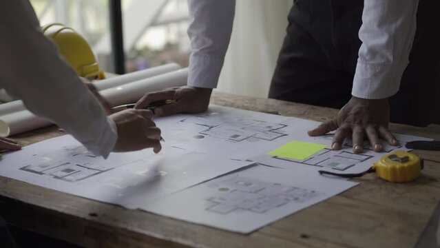 Multi-ethnic engineers, architects discuss construction plans. Engineers work on successful engineer blueprints for planning and teamwork ideas. 4K Video