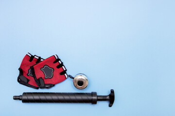 cycling gloves, padlock and bell on a blue background with copy space
