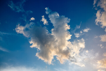 White fluffy cumulonimbus storm clouds in deep blue sky