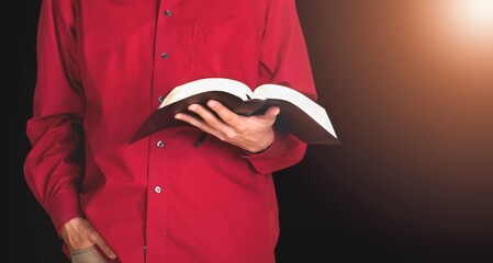 Young man holding bible book on sun light.