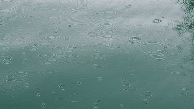 Rain Dropping on Blue sea water. Rainy Season in Tropical Countries. Tropic Rain in Wet Season. 