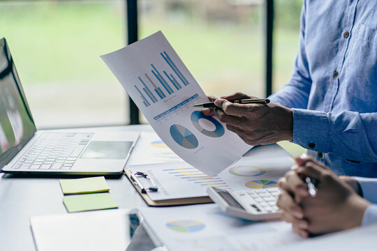 Serious businessman in office working on laptop Computers and documents View paper, graphs, reports, charts, analyze graphs with modern laptop computers.