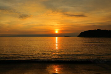 秋の逗子海岸の夕暮れ、夕焼けに染まる海と日没直前の夕陽