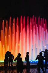 People looking at an impressive and colorful fountain in the Magic water circuit at Reserve park, Lima, Peru