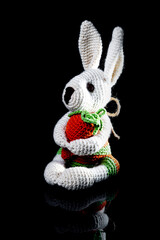 Beautiful knitted toy rabbit. Old hand-made souvenirs knitted toy rabbit with a carrot