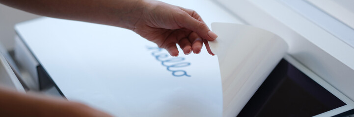 Tbilisi, Georgia - April 11, 2022: Woman removing protective film from New iMac monitor