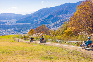 【長野県】秋の白馬岩岳マウンテンリゾートでマウンテンカートを乗る人々と北アルプス