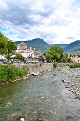 Fototapeta na wymiar Jungendstilgebäue der Kurverwaltung mit Promenade in Meran mit Fluss Passer bei Meran, Südtirol, Italien 16.09.2022 