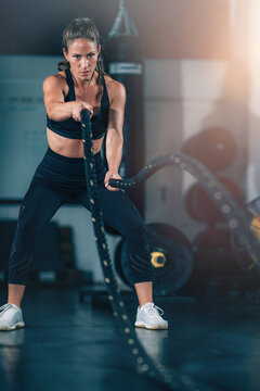 Agility training, woman exercising with rope in a gym.