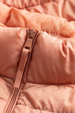 Padded coat in pinl color with zipper. Close up of detail and fabric texture