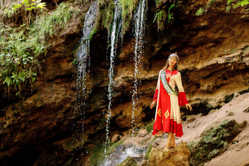 a girl in Chuvash national dress and the waterfall 