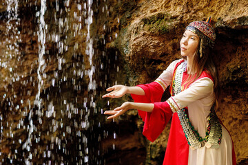 a girl in Chuvash national dress and the waterfall 