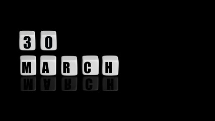 March 30th. Day 30 of month, Calendar date. White cubes with text on black background with reflection.Spring month, day of year concept