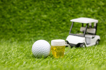 Golf cart with beer and ball are on green grass