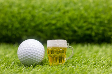 Golf ball and beer is on green grass to celebrate golfer 
