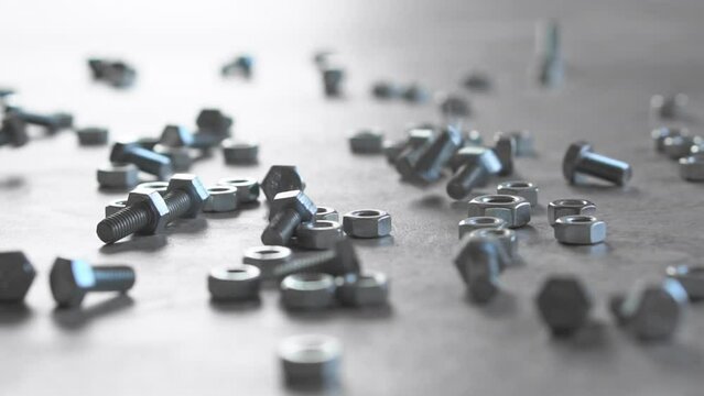 Close-up. Metal fasteners bolts and nuts fall on a white surface