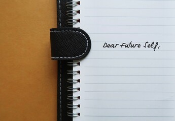 Notebook with handwritten text DEAR FUTURE SELF, a letter to convey message to future you. specific...