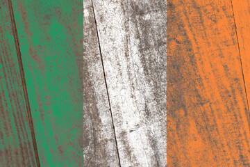 Old damaged ireland flag painted on a distressed wooden background