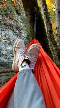 point of view laying down in hammock in autumn forest