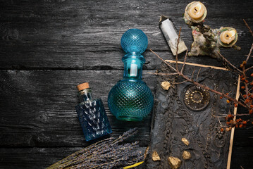 Old magic book and dry natural herbs and remedy bottle on the wooden table flat lay background with...