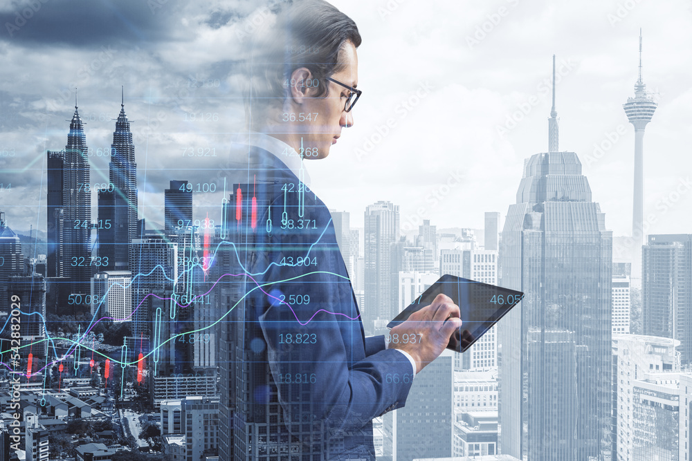 Poster businessman using pad with creative candlestick forex chart index hologram on blurry background. tra