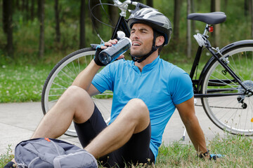 Naklejka premium guy on a bike with a bottle outdoors