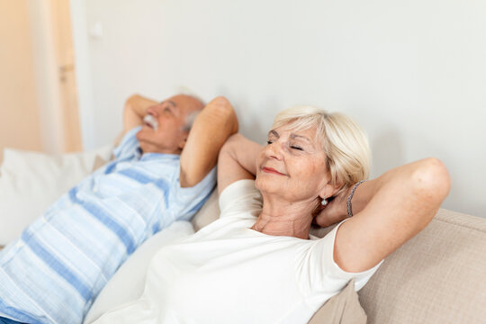 Senior aged couple relaxing on comfortable sofa together breathing fresh air at home, calm old mature man and woman enjoying no stress free weekend peaceful rest having healthy daytime nap on couch