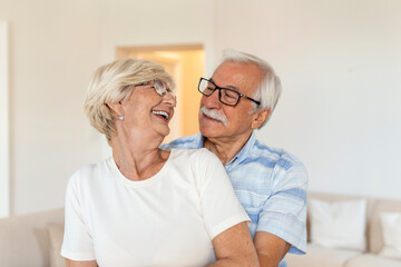 Head shot portrait smiling older woman dancing with man, happy mature wife and husband hugging, standing in living room, senior family enjoying tender moment, celebrating anniversary