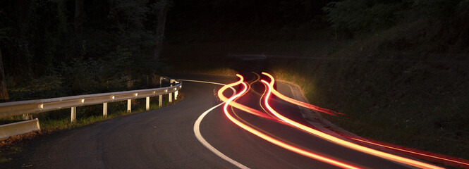 Car lights driving on a curve of the road at night
